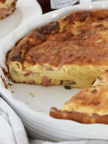 A baking dish filled with a cheesy, creamy bacon quiche.