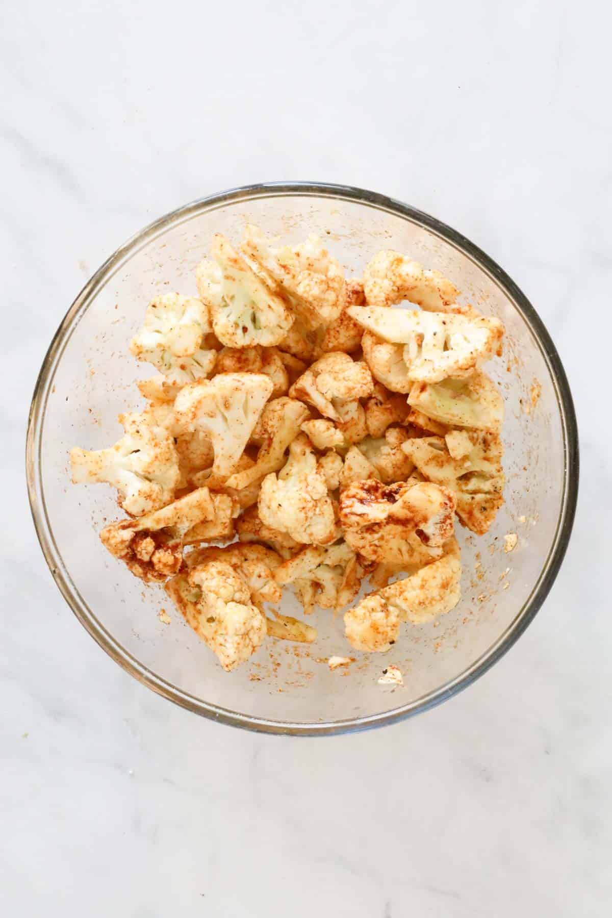 The cauliflower florets coated in the seasonings.