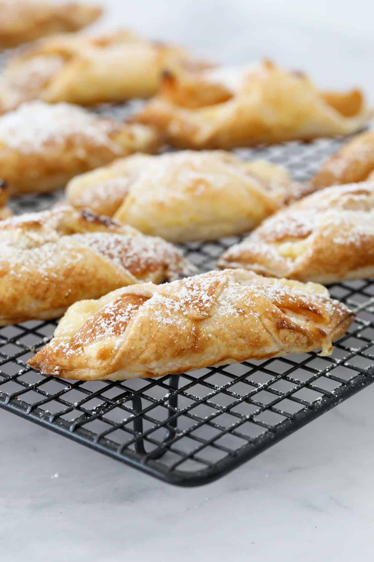 Apricot danishes on a black wire cooling tray.