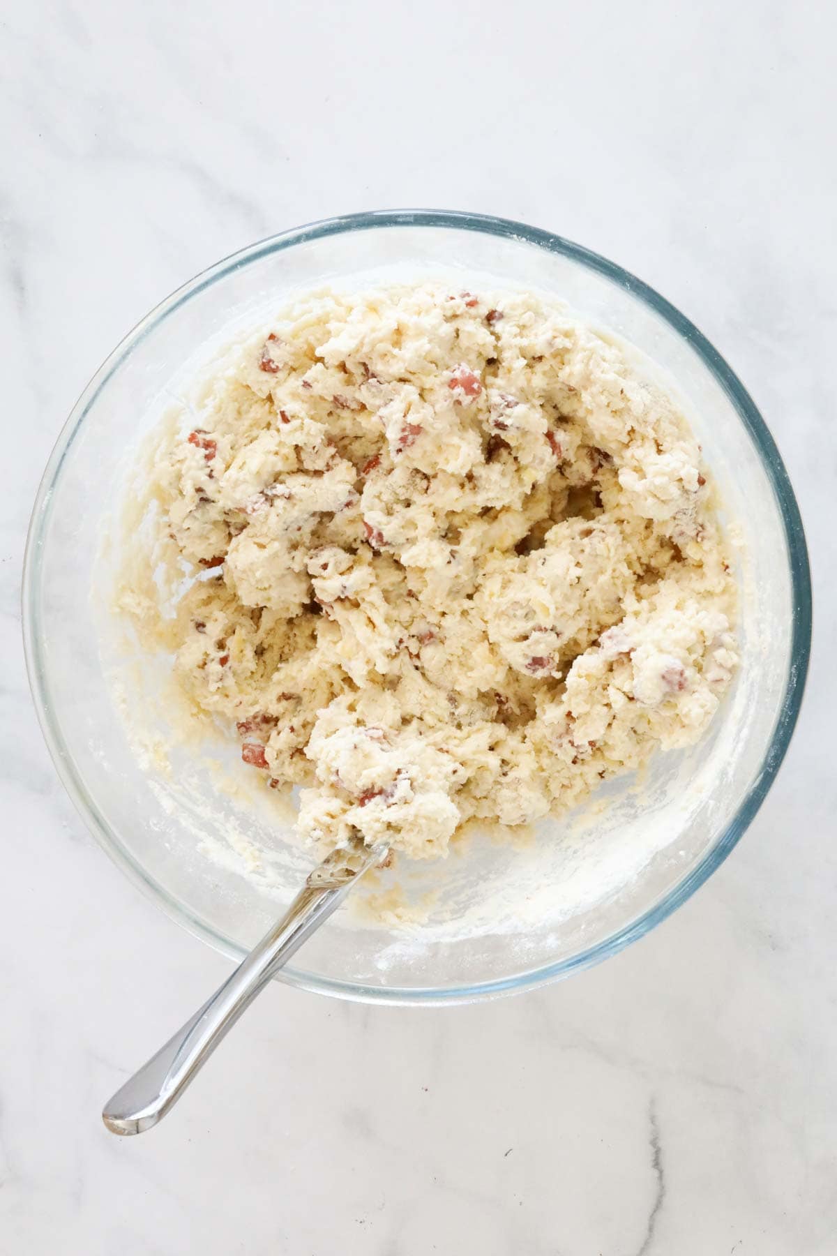 The mixed scone dough in a glass mixing bowl.