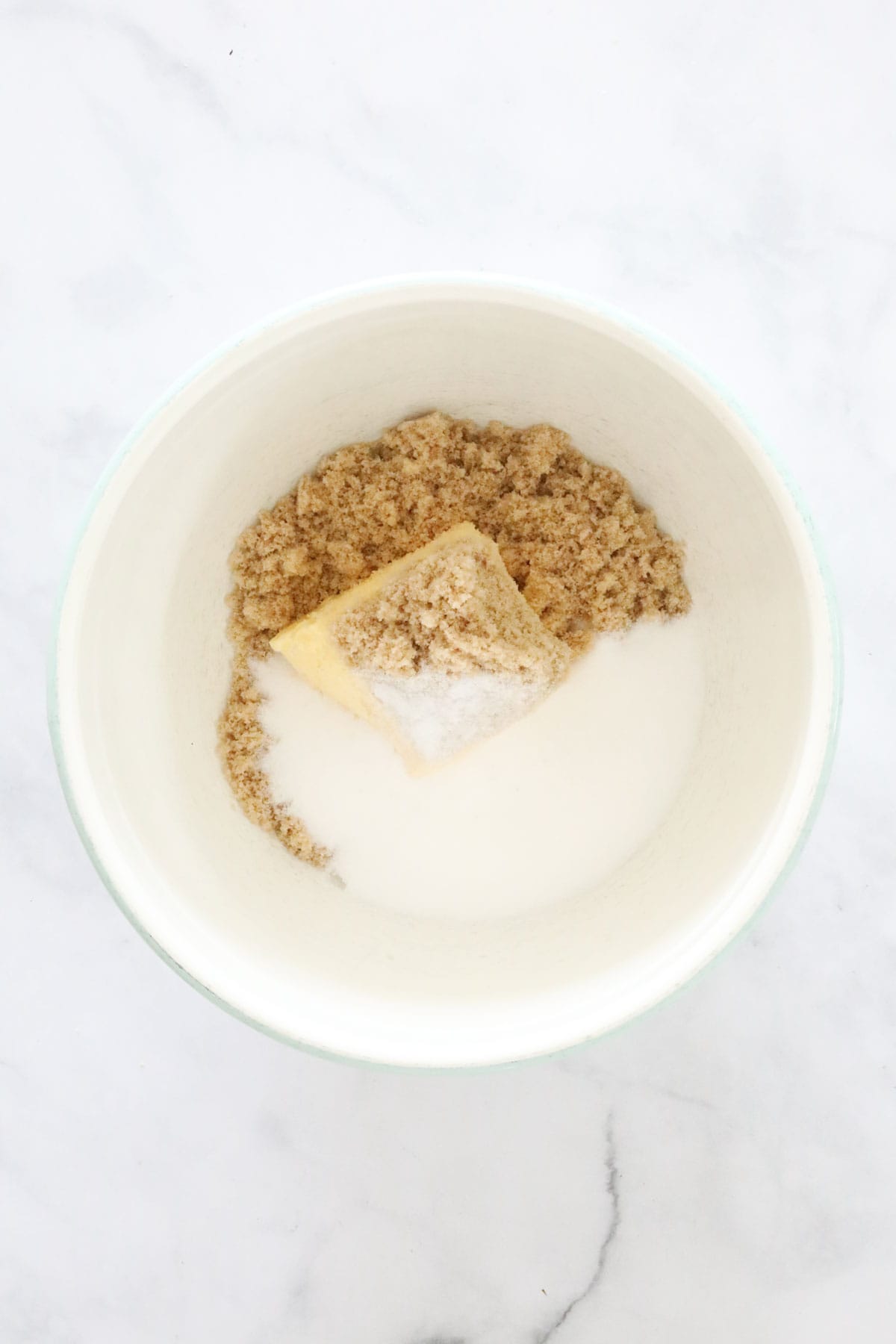 Butter, brown sugar and white sugar in a bowl.