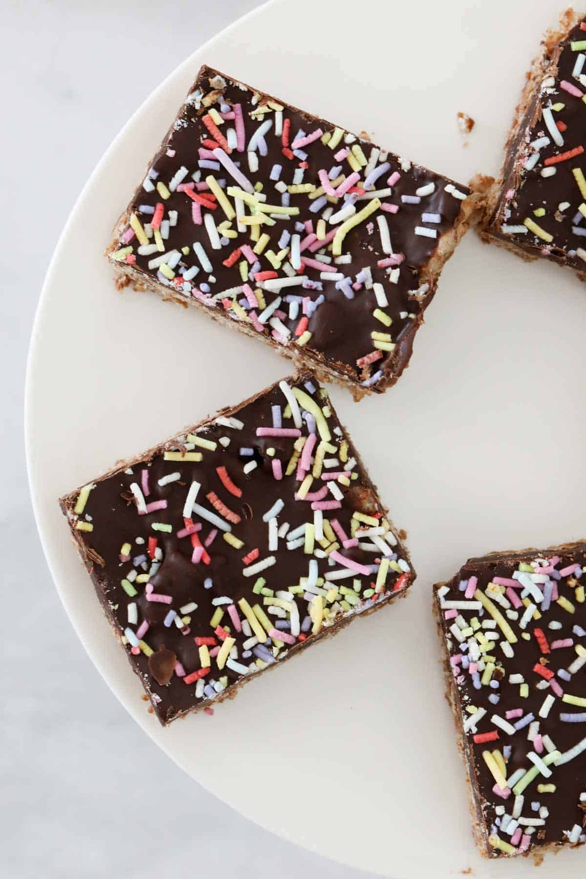 Overhead view of the chocolate rice bubble slice on white cake platter.