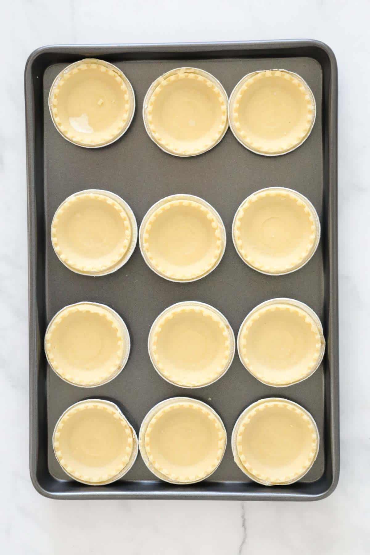 The pastry cases on a baking tray.