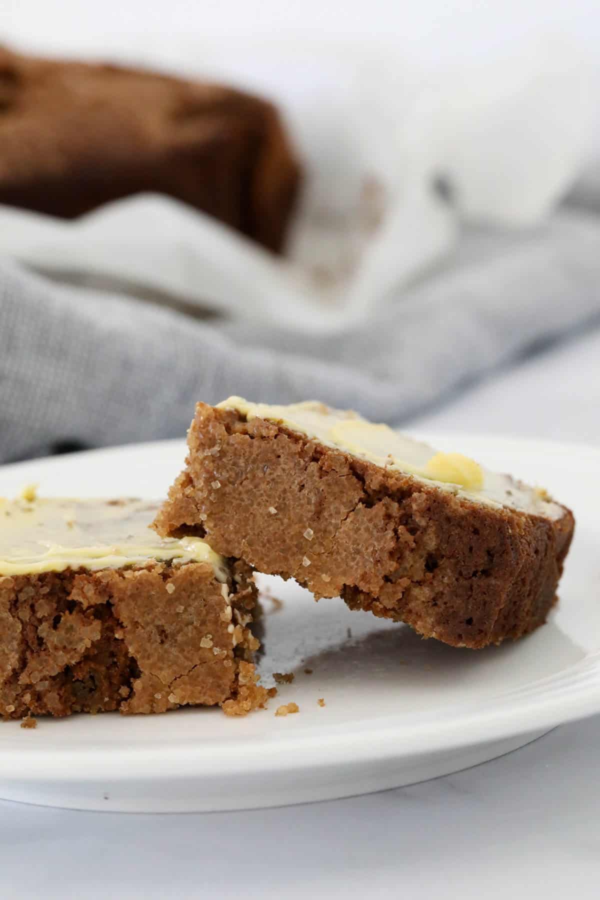 A side view of two pieces of buttered coffee loaf.