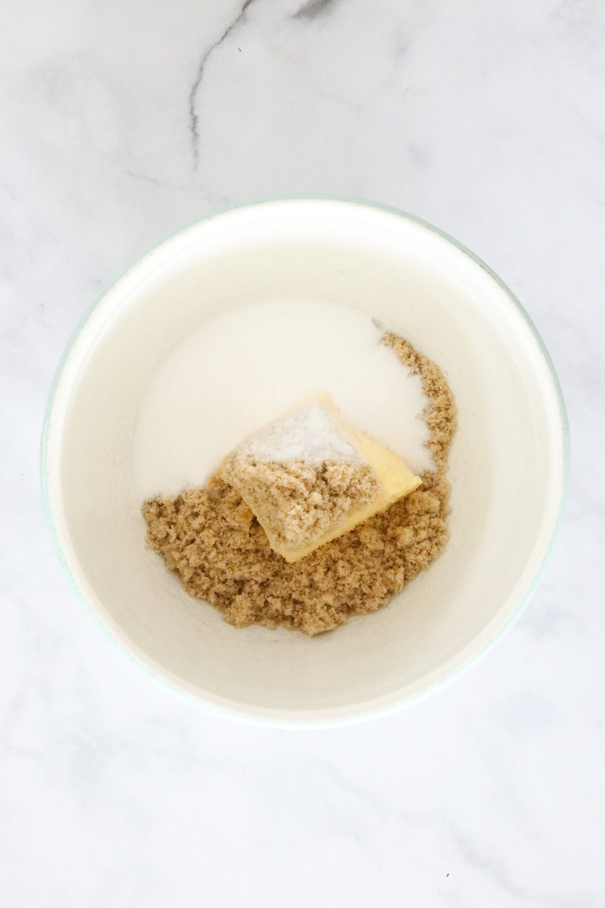 Butter, brown sugar and caster sugar in a mixing bowl.
