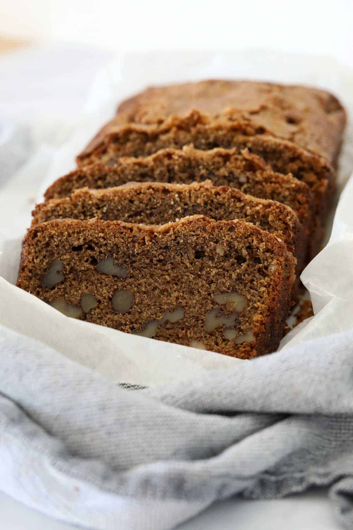 Slices of baked coffee and walnut loaf on a tea towel.