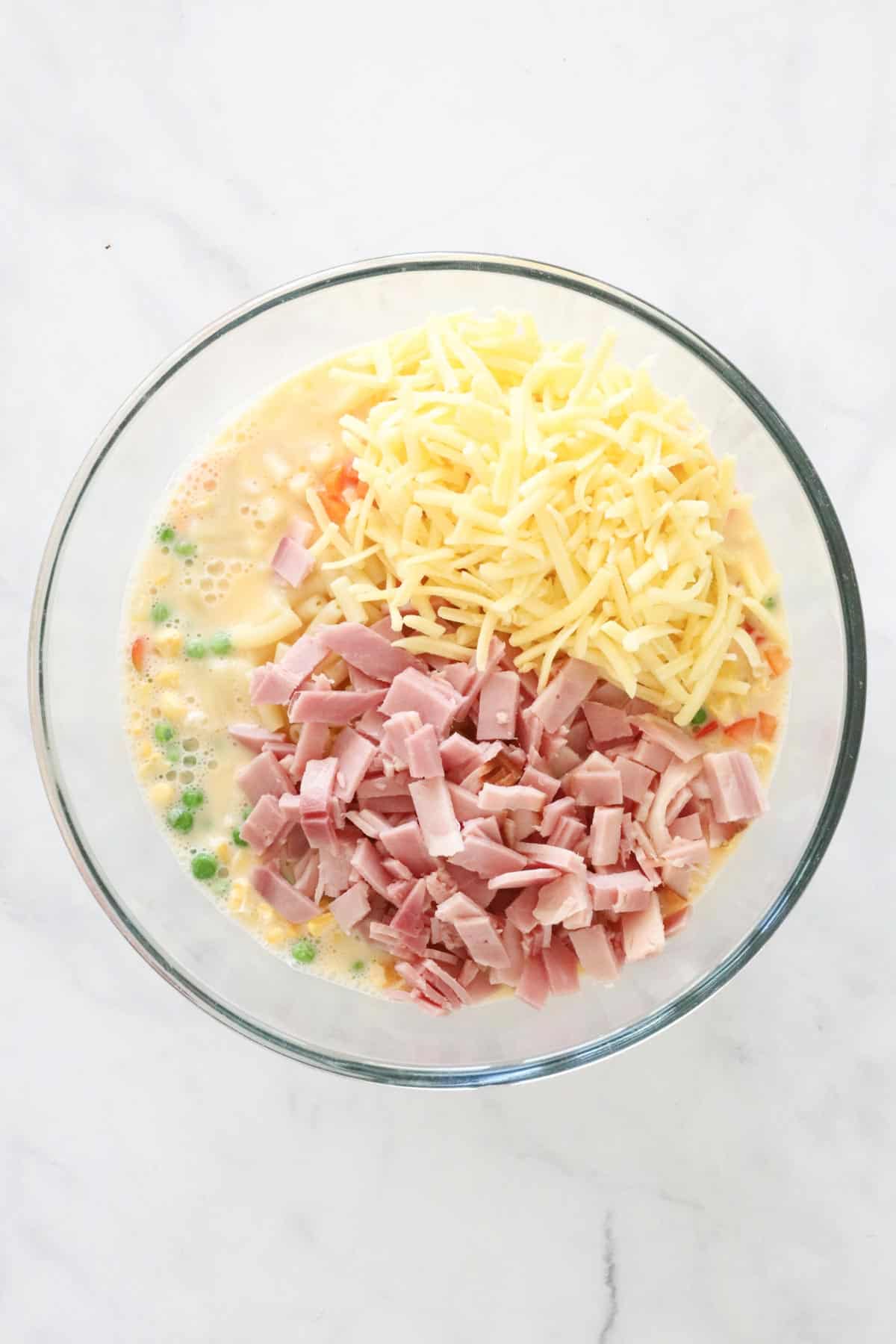 The vegetables, chopped ham and cheese added to the beaten eggs.