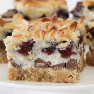 A layered slice with coconut, nuts, biscuit base, chocolate, dried fruit and condensed milk.