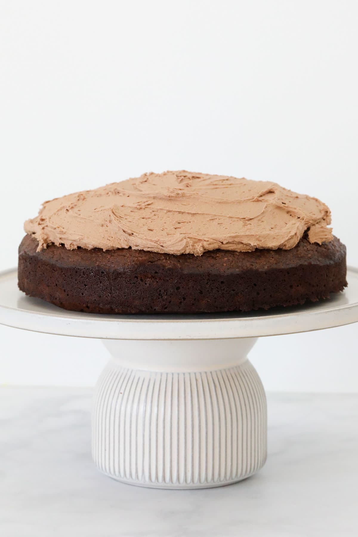 A chocolate cake topped with the chocolate buttercream icing.