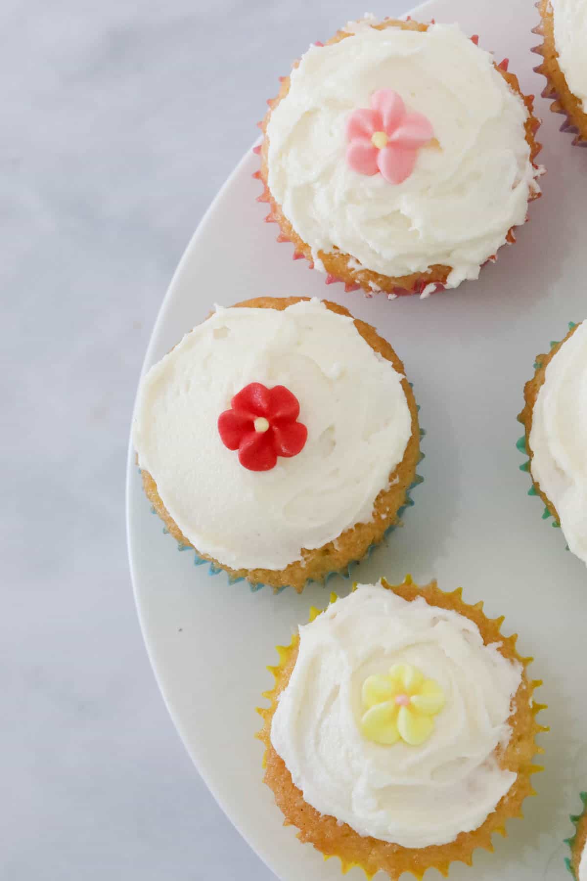 Three mini cupcakes on a white cake stand.