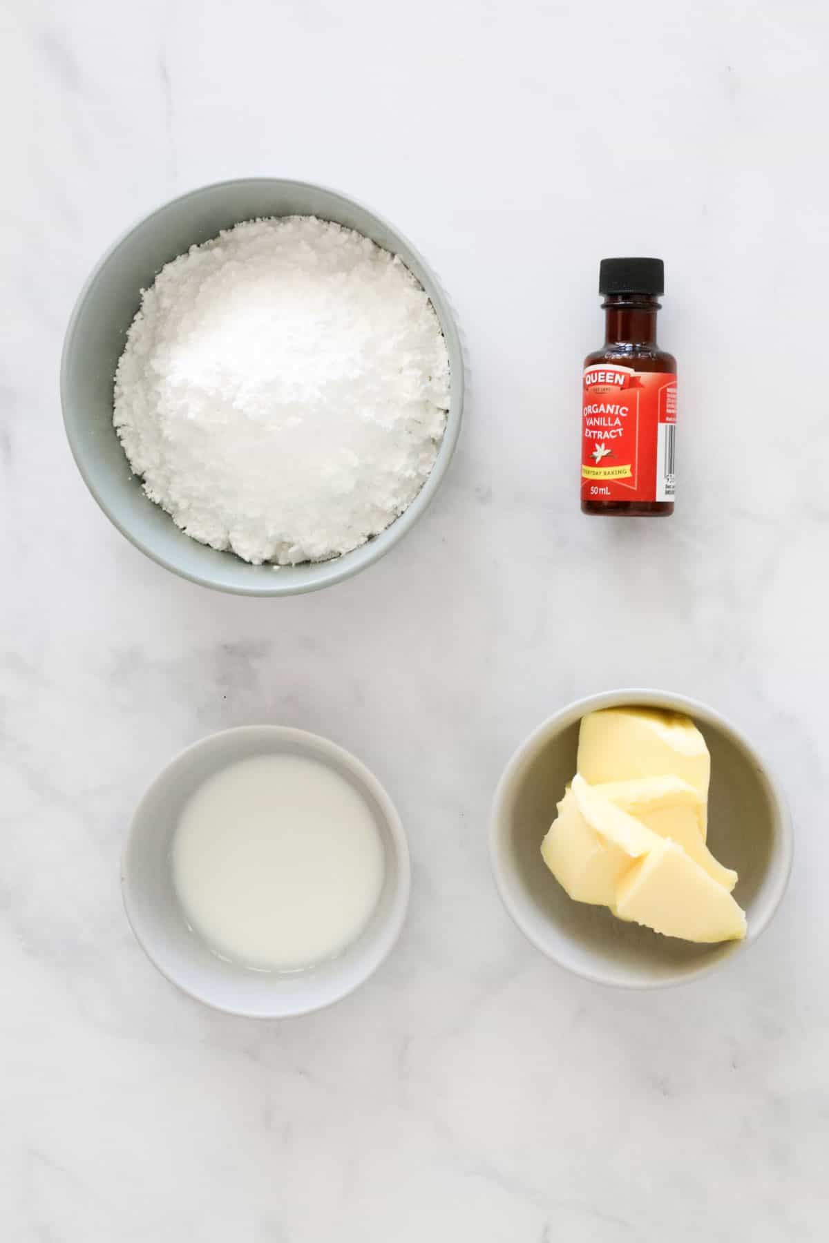 Ingredients needed to make vanilla buttercream weighed out and placed in individual bowls.