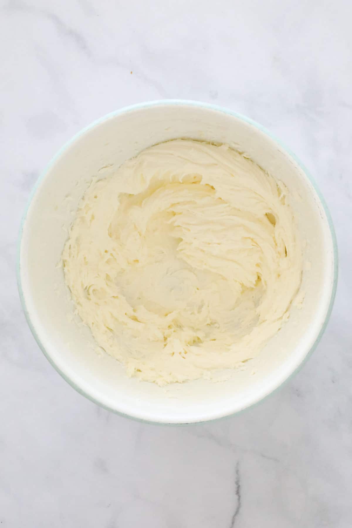 Beaten vanilla buttercream in a mixing bowl.