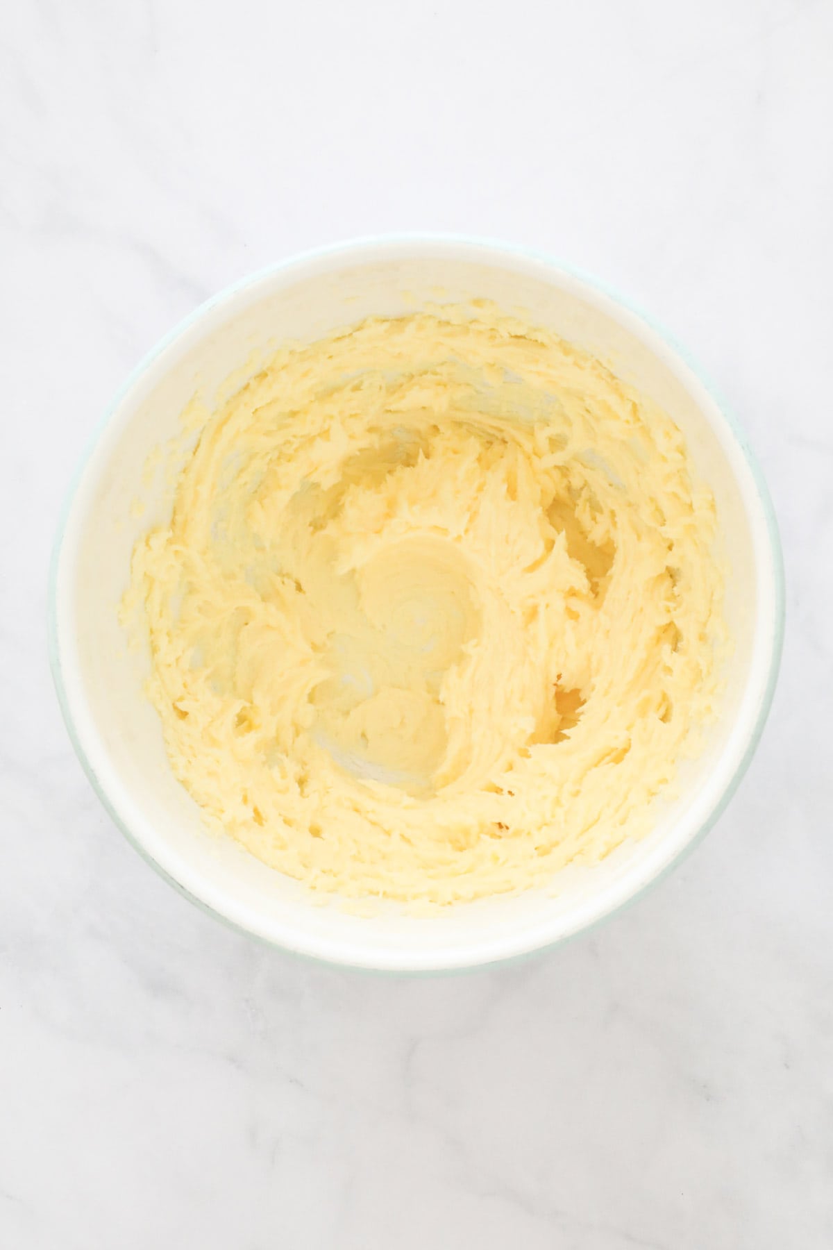 Butter and sugar creamed together in a mixing bowl.