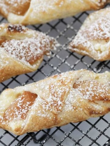 Flakey apricot danishes sprinkled with icing sugar.