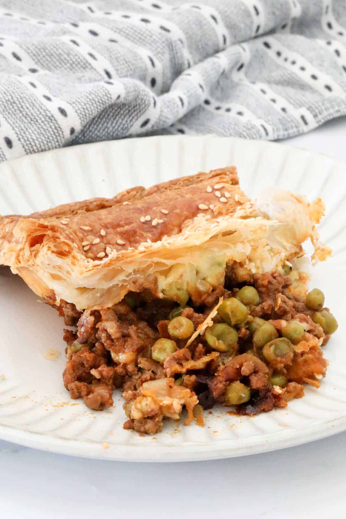 A portion of beef and mince pie on a white plate.