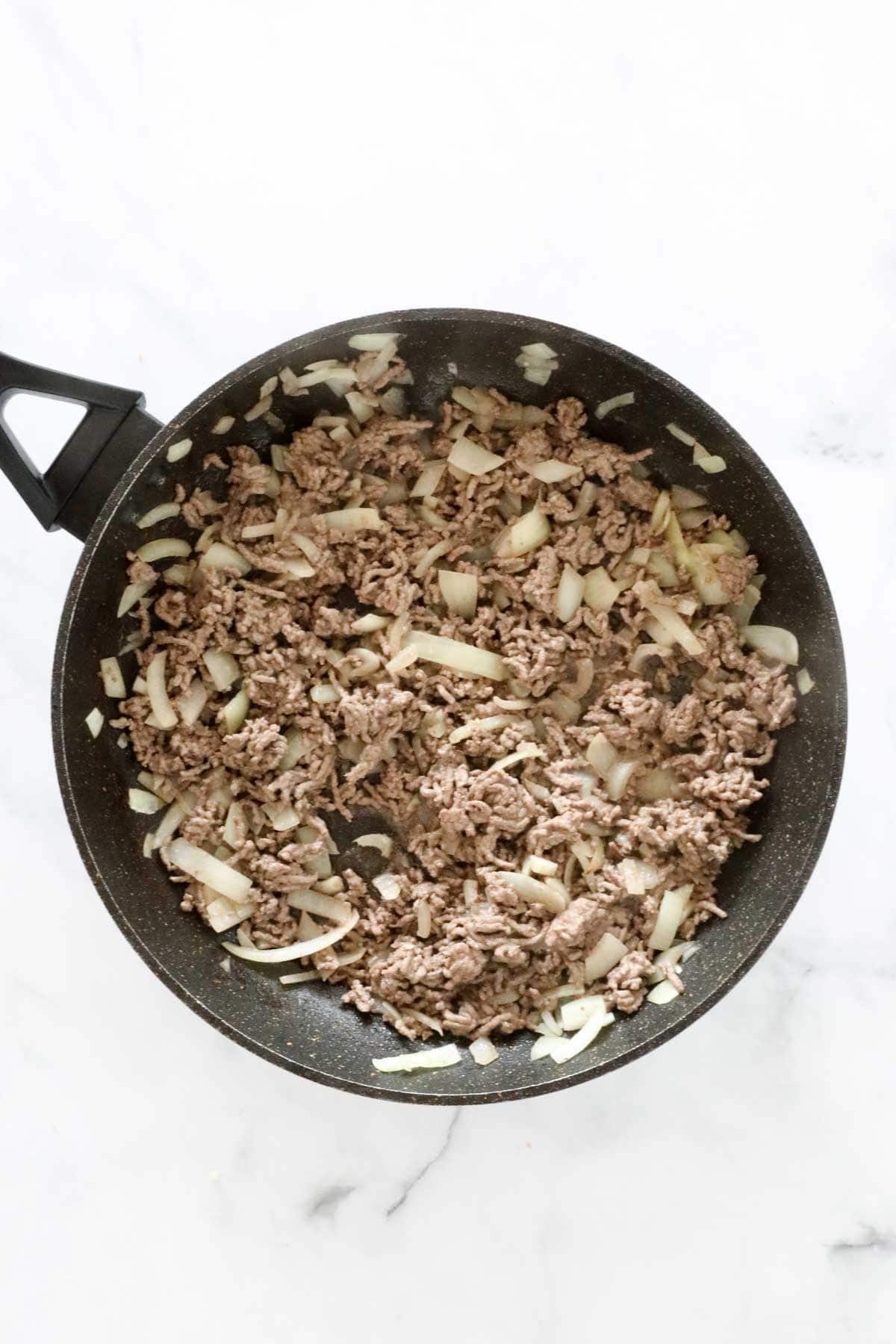 Browned minced beef, onion and garlic in a frying pan.