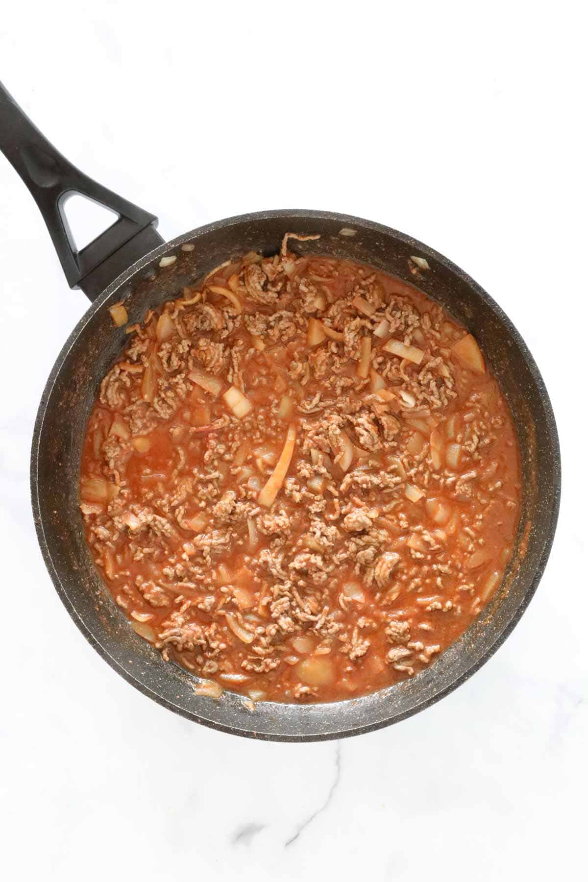 The thickened beef mince mixture in the frying pan.