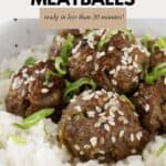 Spicy beef meatballs served with rice and sprinkled with sesame seeds and spring onions.