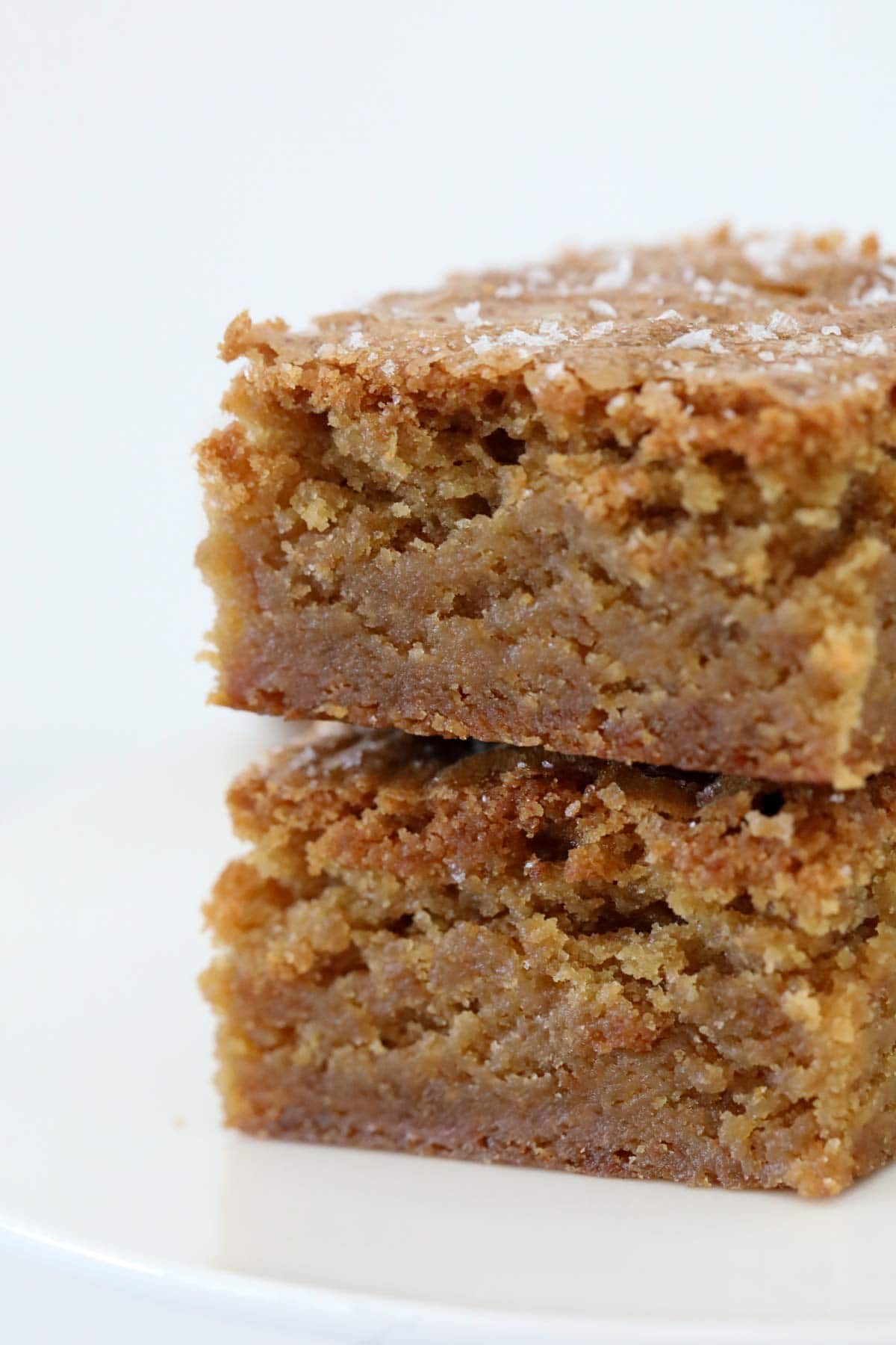 Close up side view of a stack of two butterscotch blondies showing their moist texture.