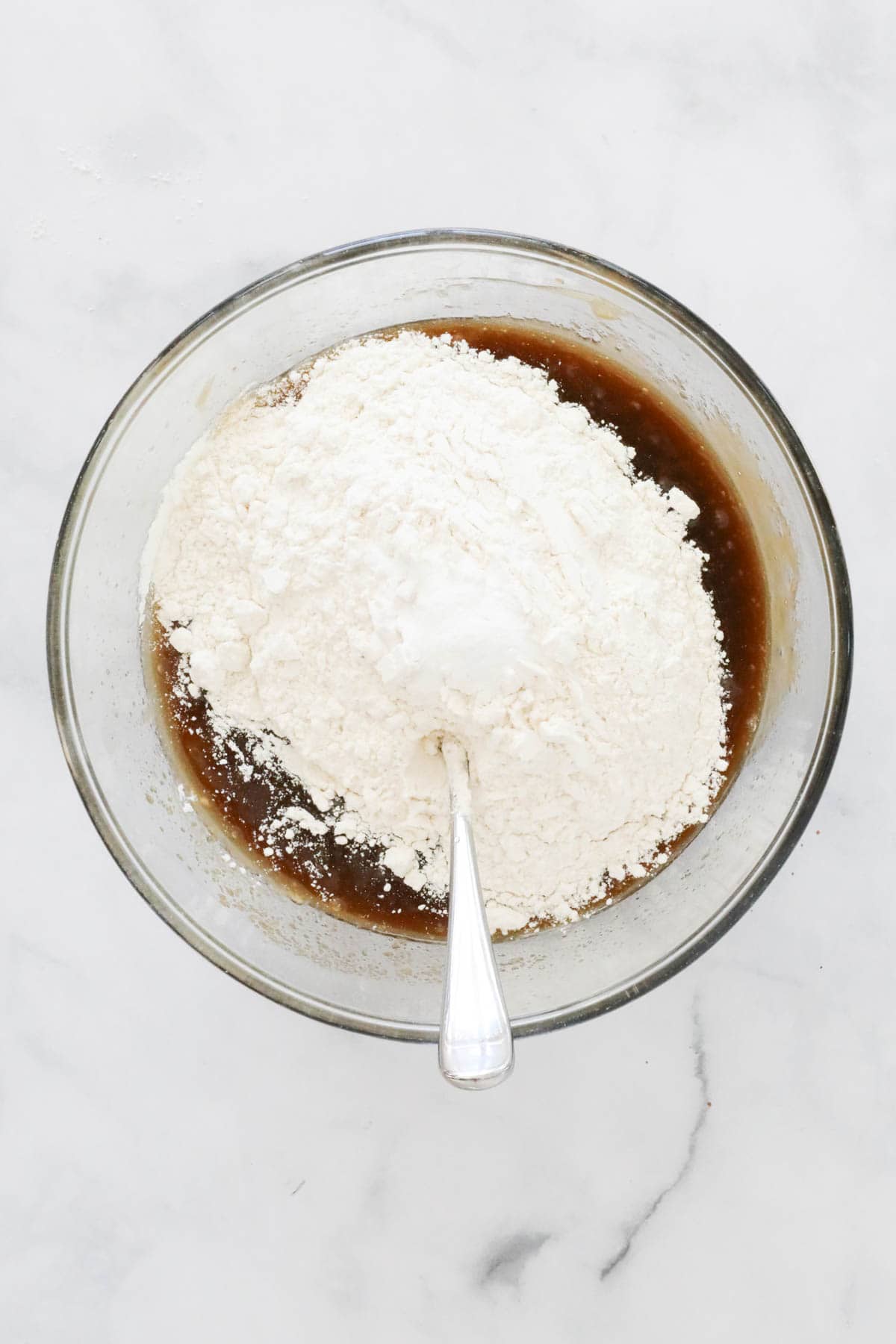 Sifted flour and baking powder added to the mixture in the bowl.