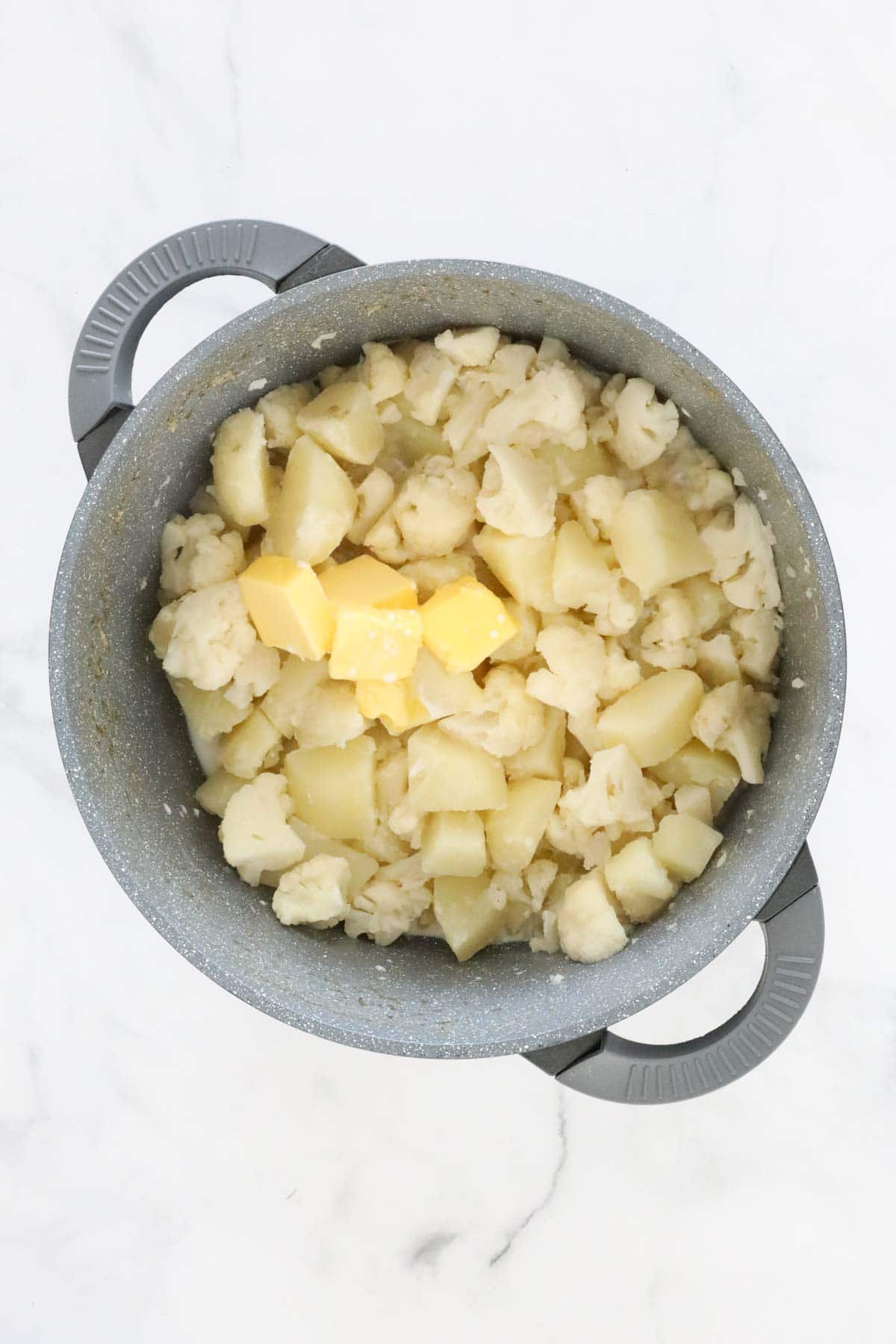 Butter and milk added to the cooked and drained vegetables.