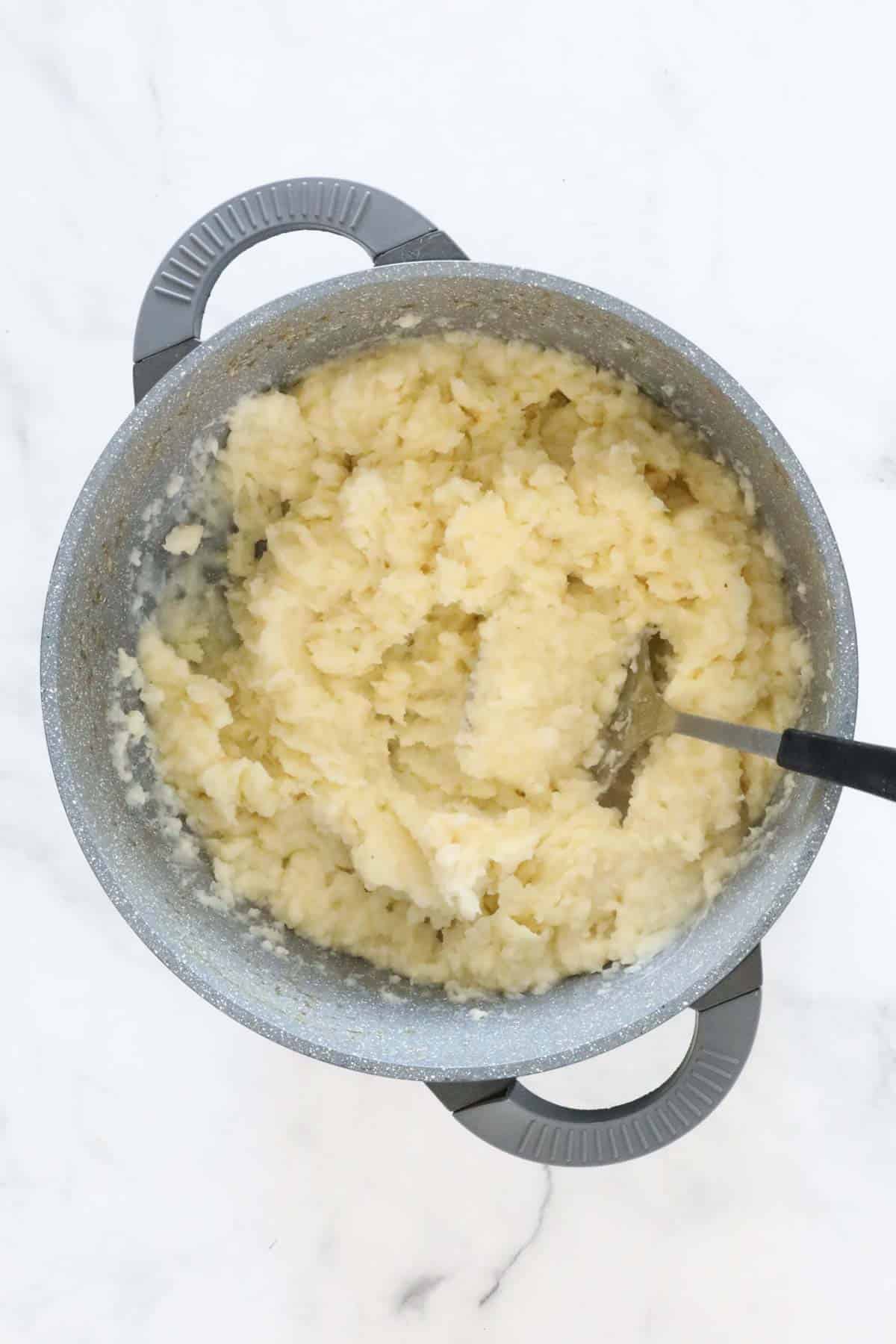 The mashed cauliflower and potatoes in the cooking pot.