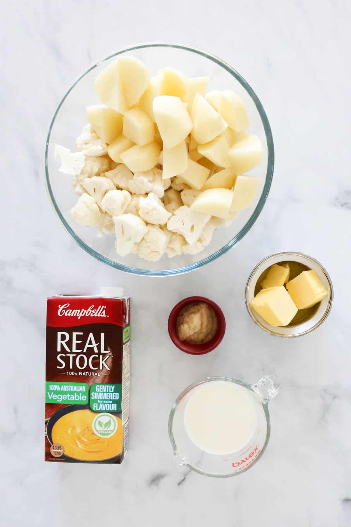 The ingredients needed to make the recipe placed in individual bowls on a bench top.