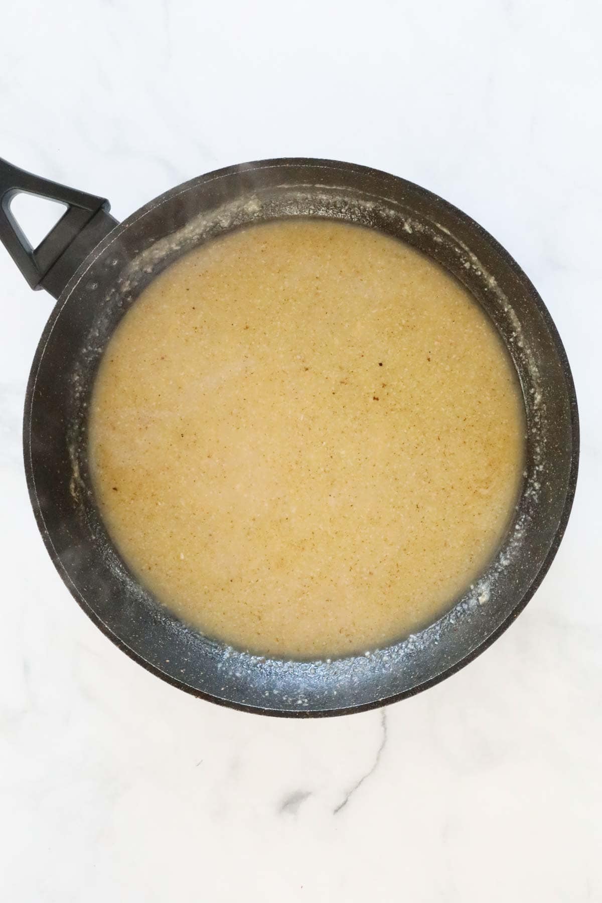 Chicken stock liquid added to the frying pan.