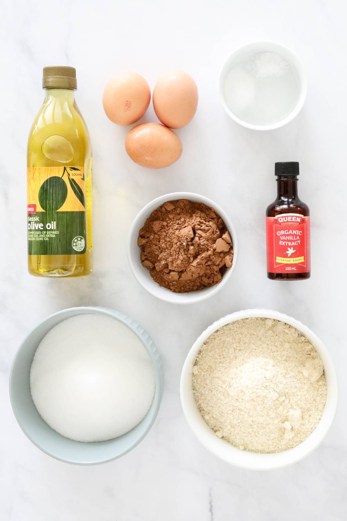 Ingredients for chocolate cake placed on a bench top.