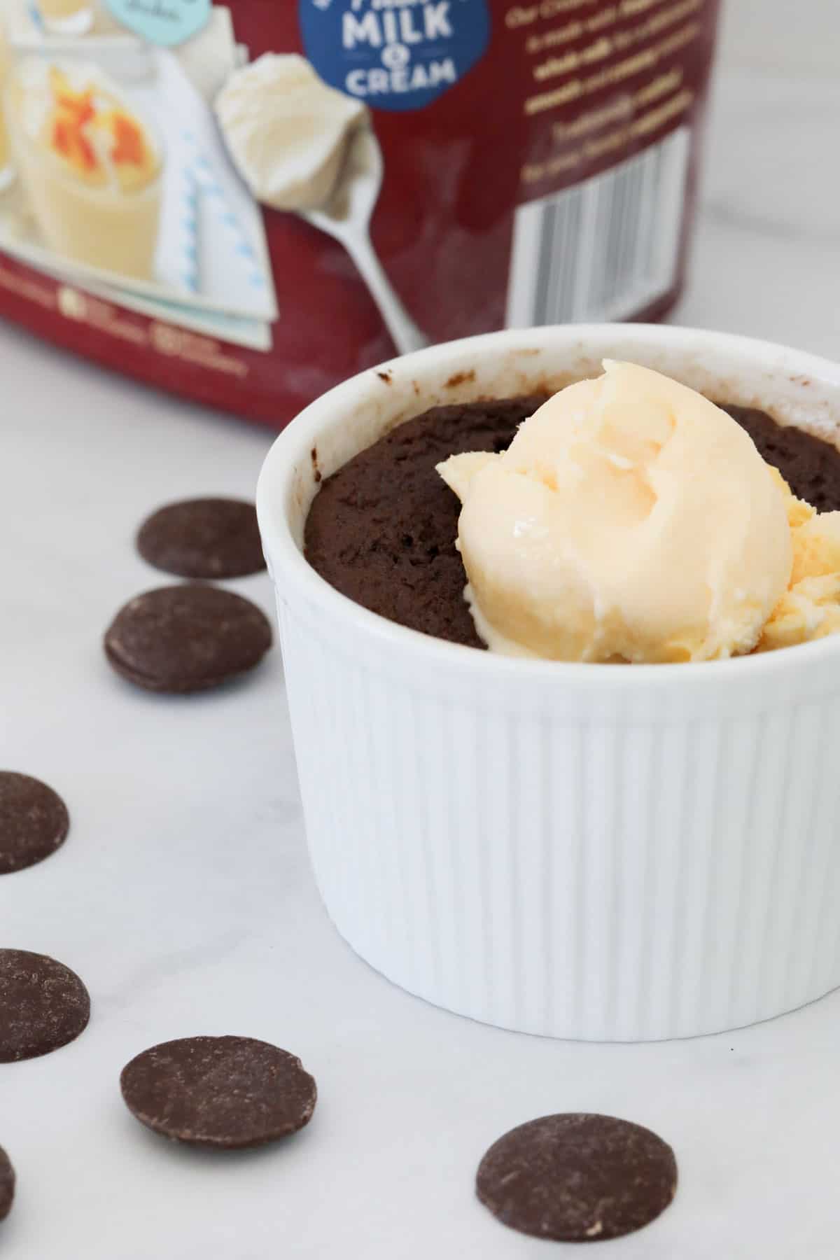 Chocolate mug cake served with a scoop of vanilla ice cream.