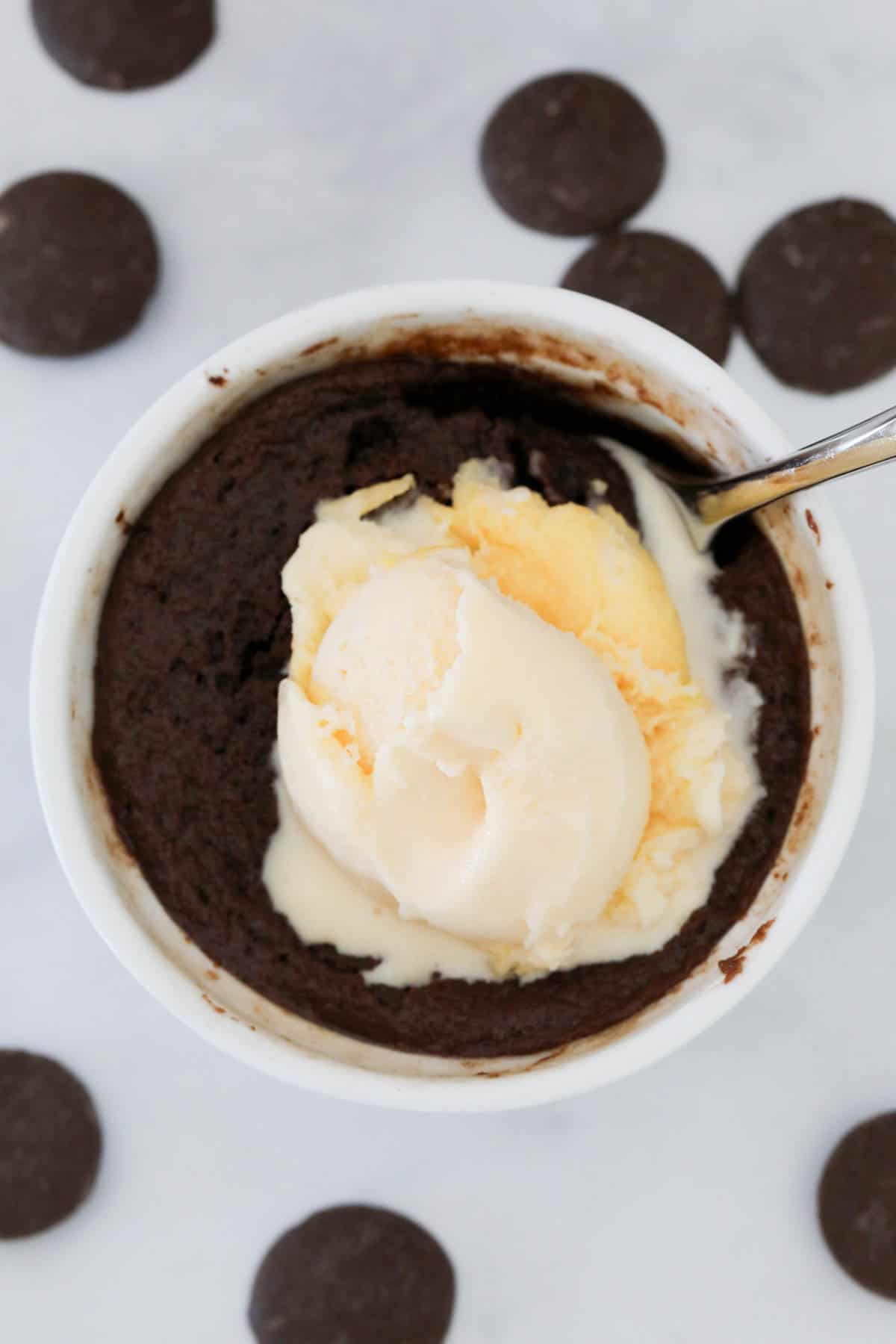 Chocolate lava mug cake served with a scoop of ice cream.