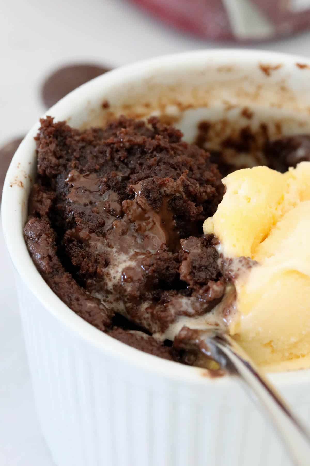 A spoon holding up a spoonful of the chocolate lava cake.