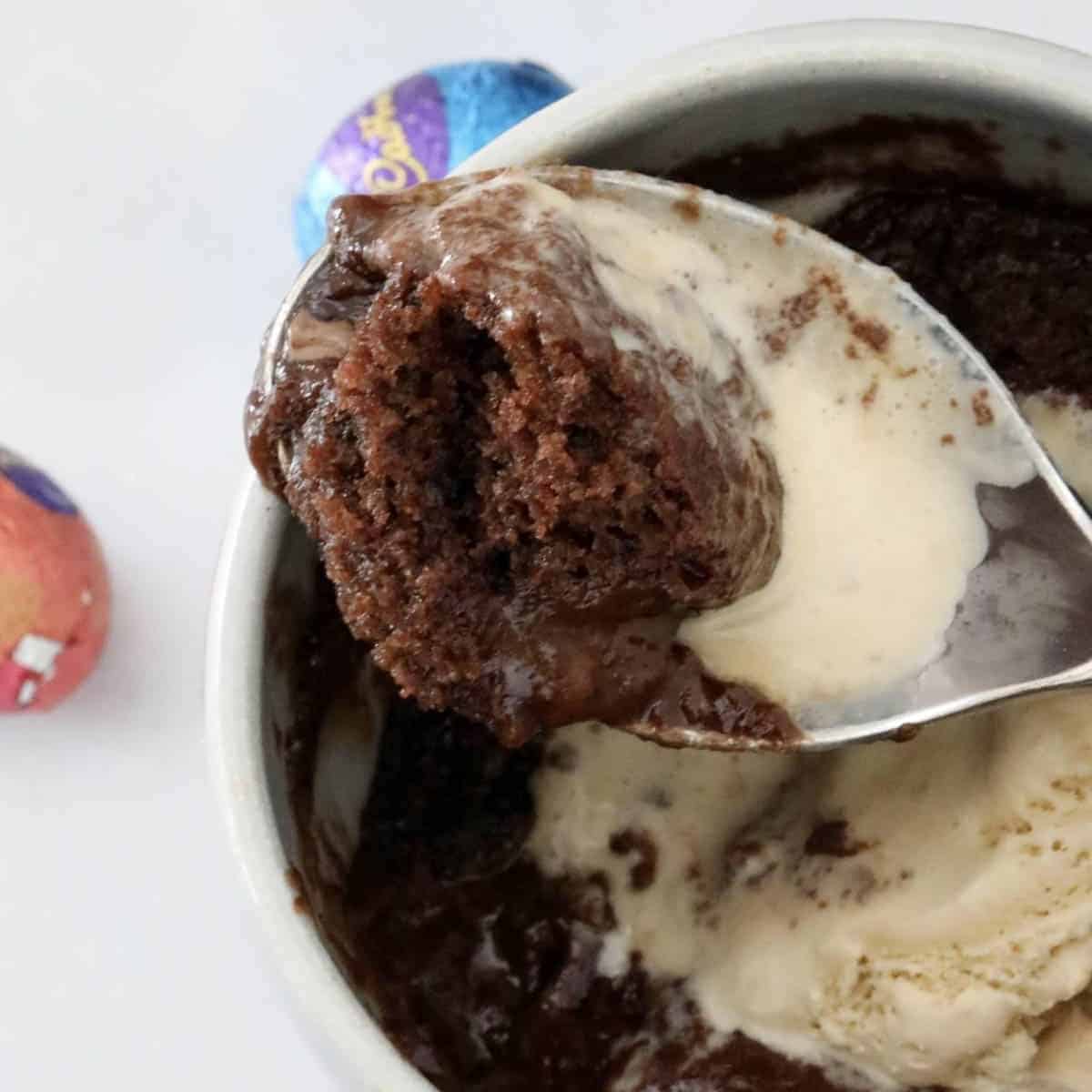 A spoonful of chocolate Easter egg mug cake with ice cream.