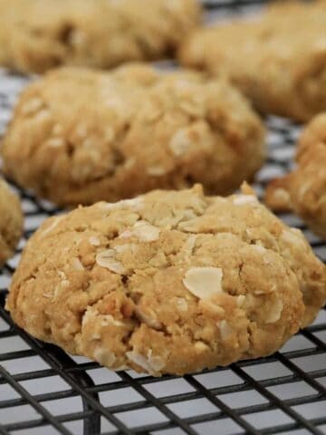 Soft and chewy gluten free ANZAC biscuits on a cooling rack.
