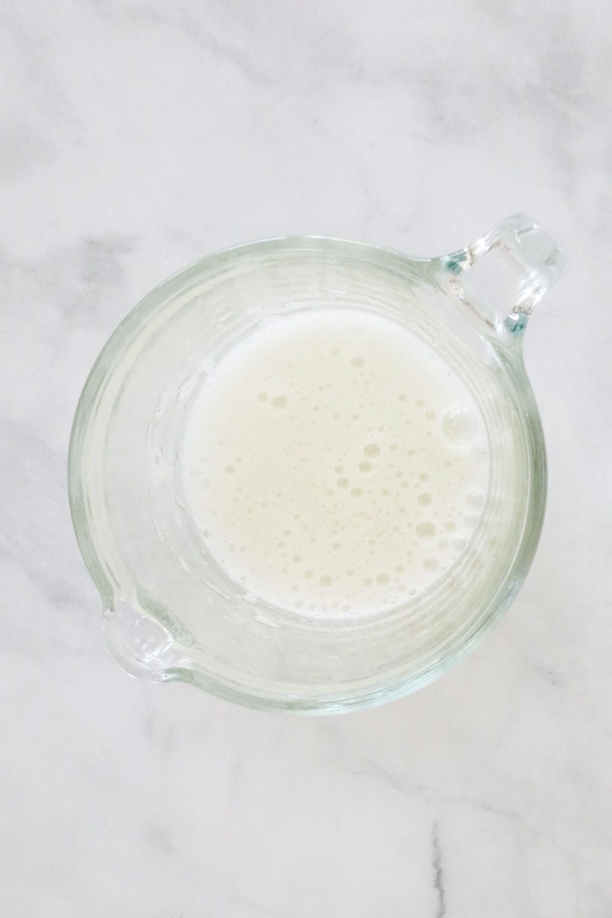 The whisked egg white in a glass jug.