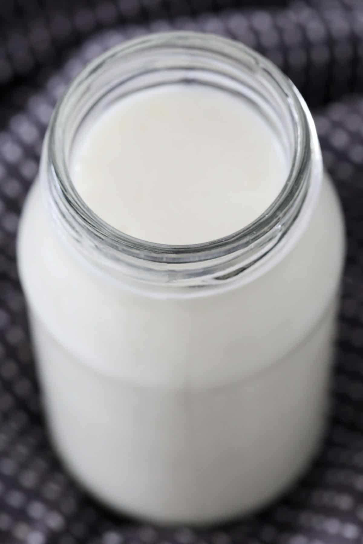 A shot looking into a small bottle filled with cultured milk.