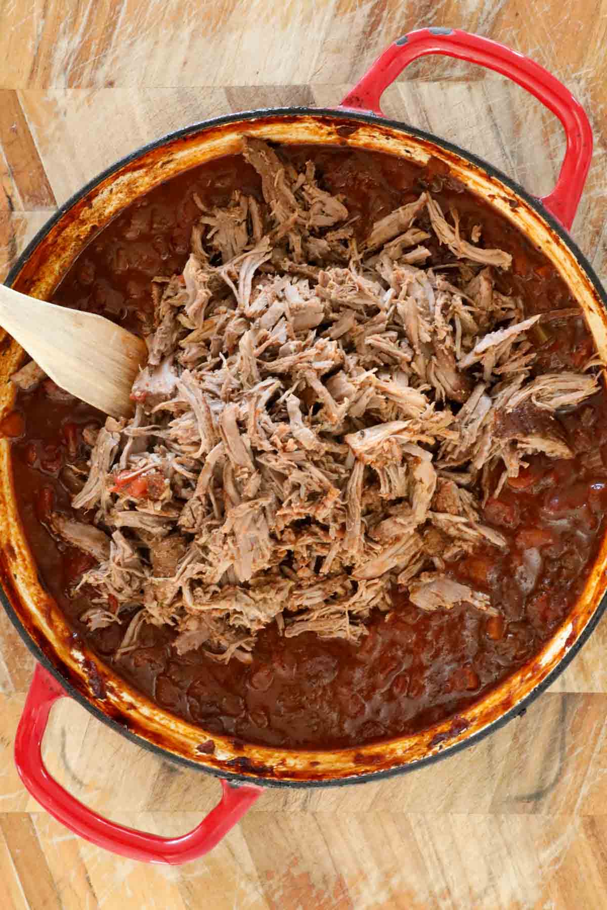 The shredded lamb returned to the ragu sauce in the pan.