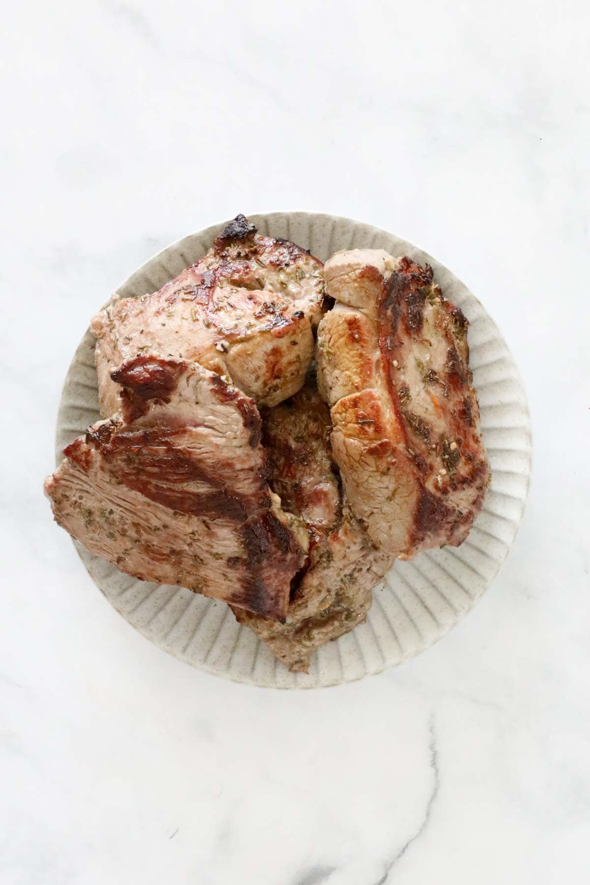 Browned lamb pieces on a plate.