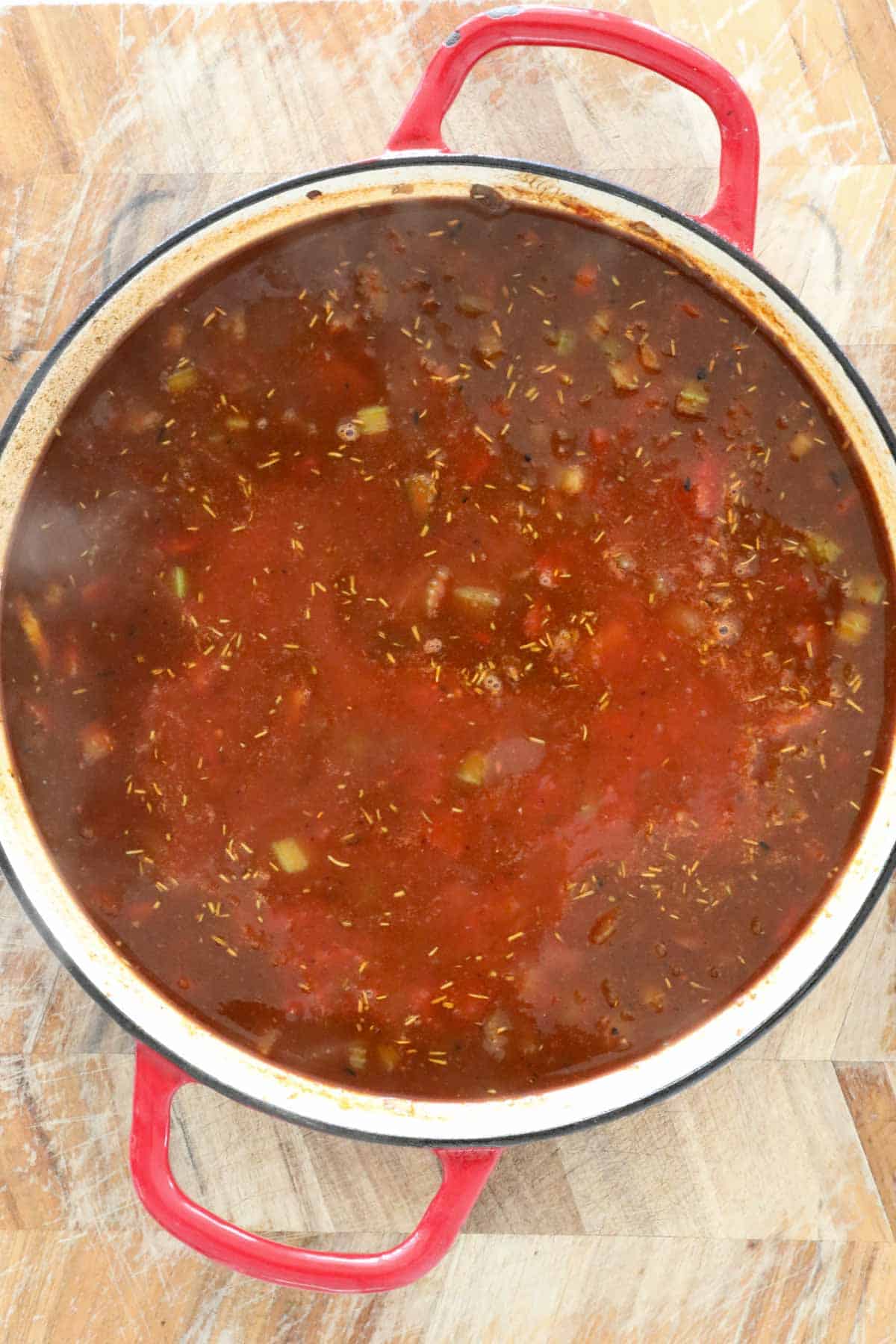 Beef stock and diced tomatoes added to the pan.