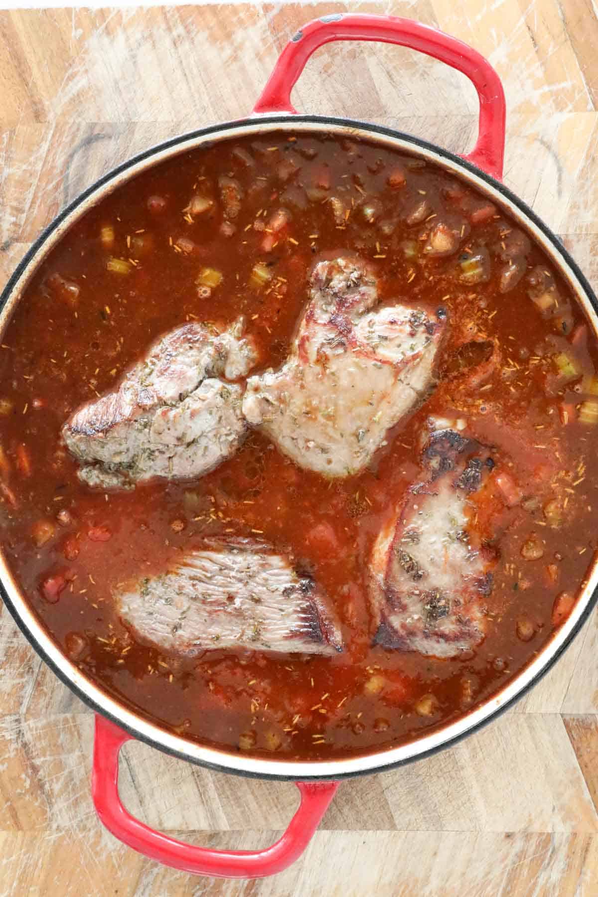 The browned lamb pieces returned to the pan.