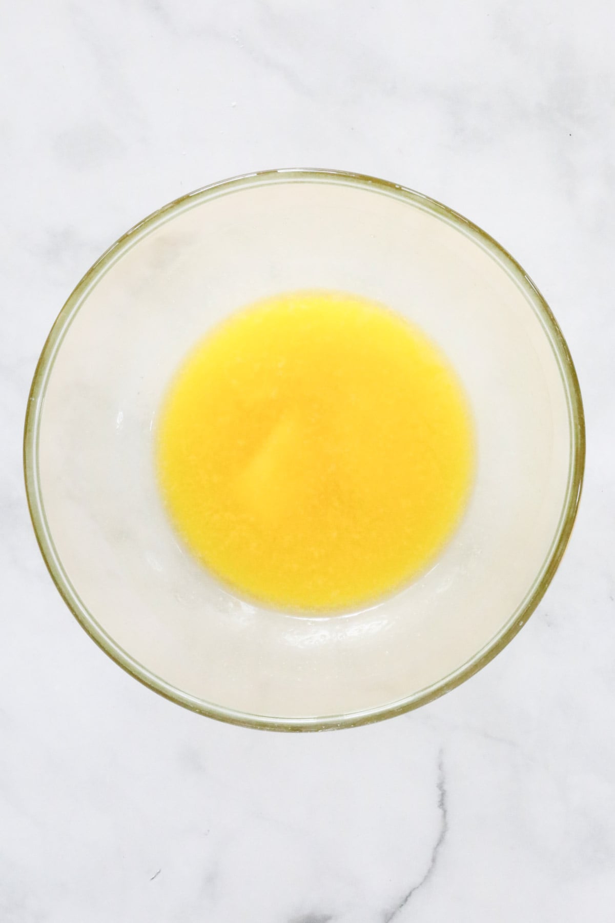 Butter melted in a clear glass bowl.