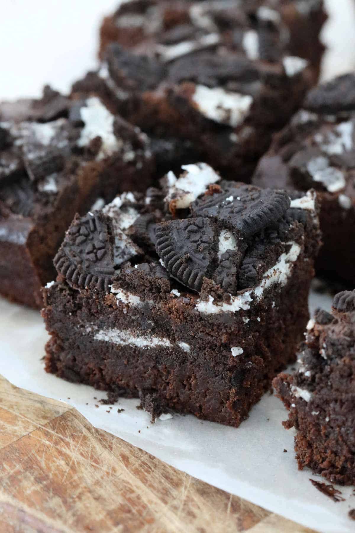 A square of Oreo brownie on a wooden board.