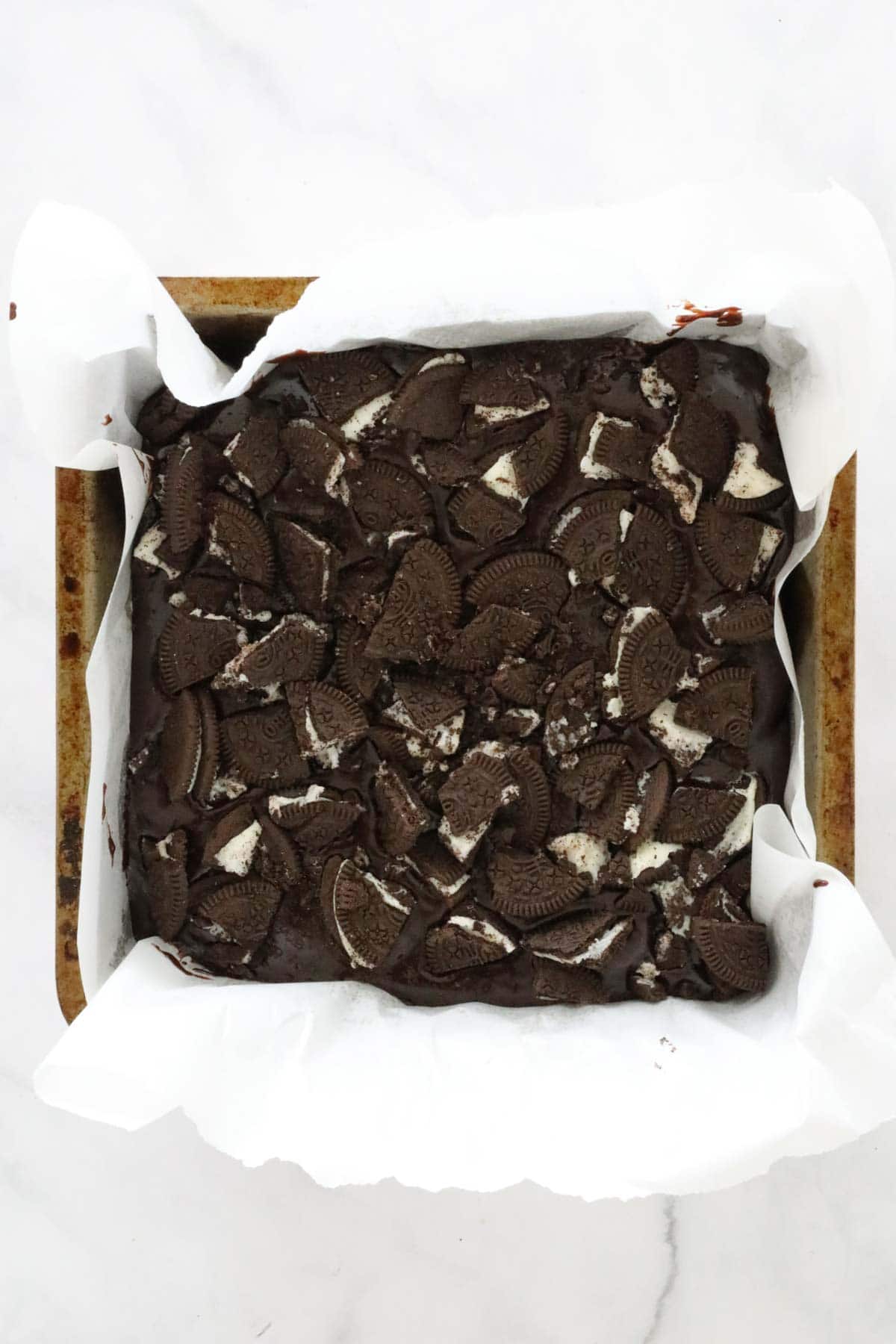 Broken Oreo biscuits placed on top of the brownies.