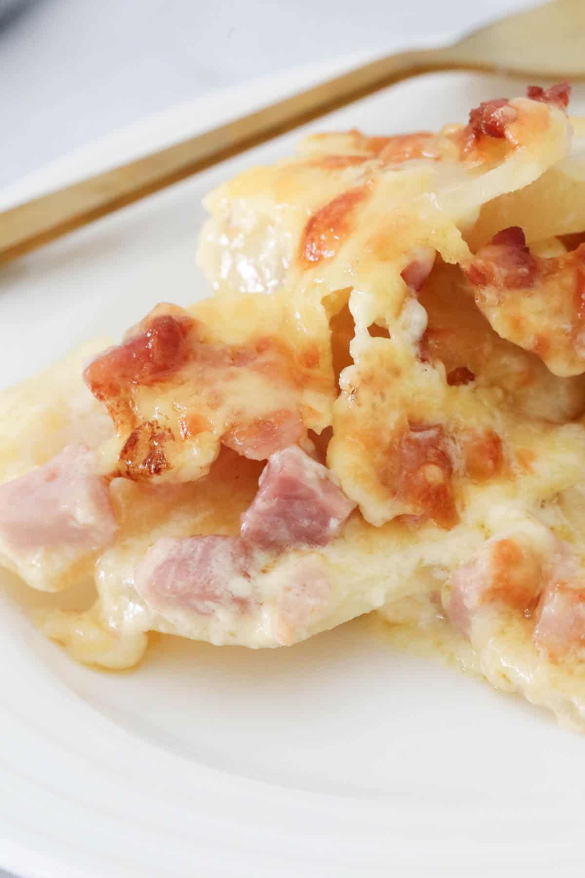 A serve of creamy potato and bacon on a plate.