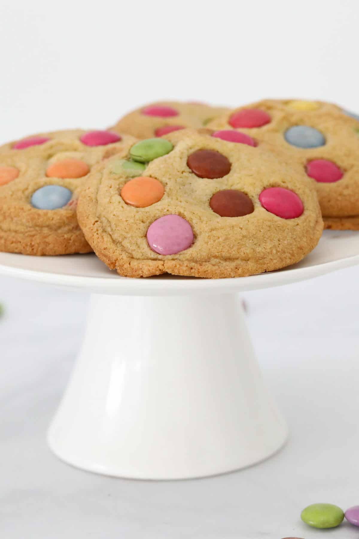 A cake stand topped with Smarties cookies.