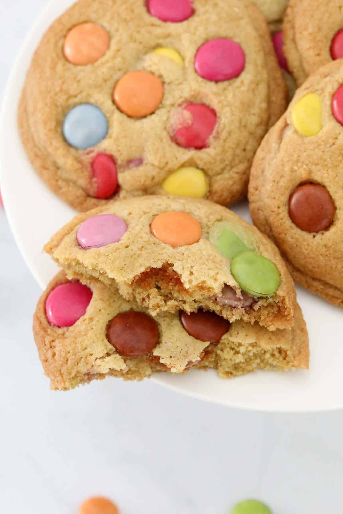 A cookie with Smarties on top, broken in half.