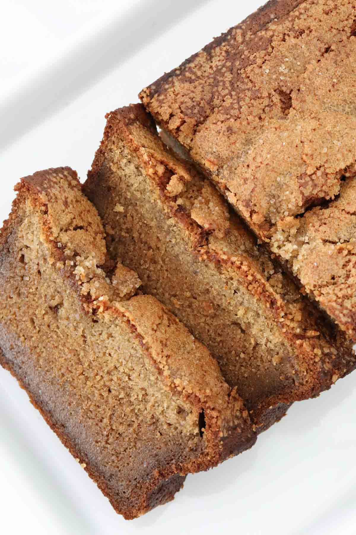 An overhead shot of a banana loaf with two slices cut from one end.