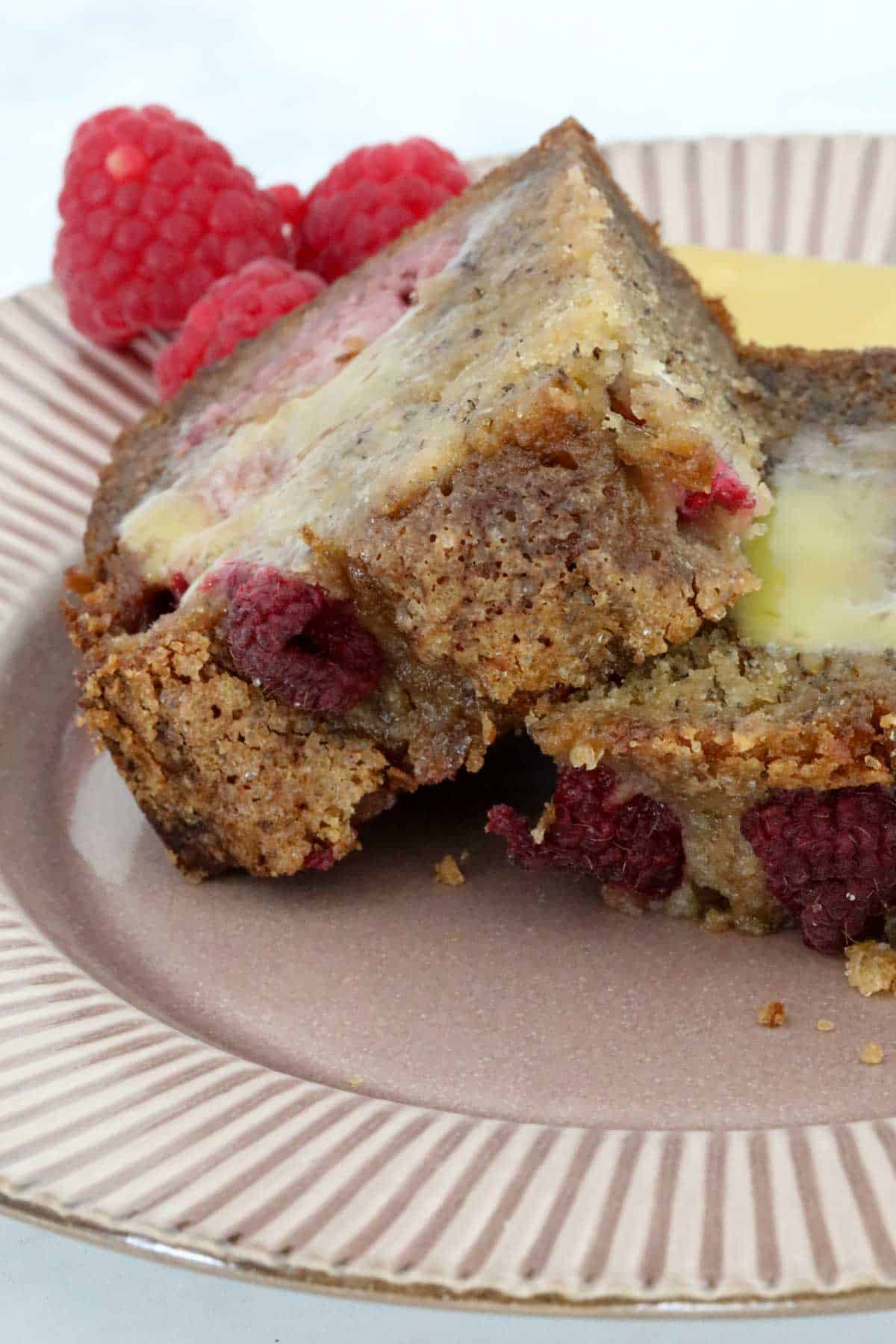 A buttered slice of banana raspberry bread on a plate.