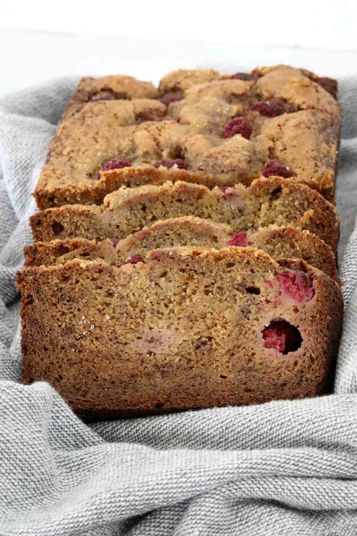 Looking towards a loaf of banana bread with several slices cut.