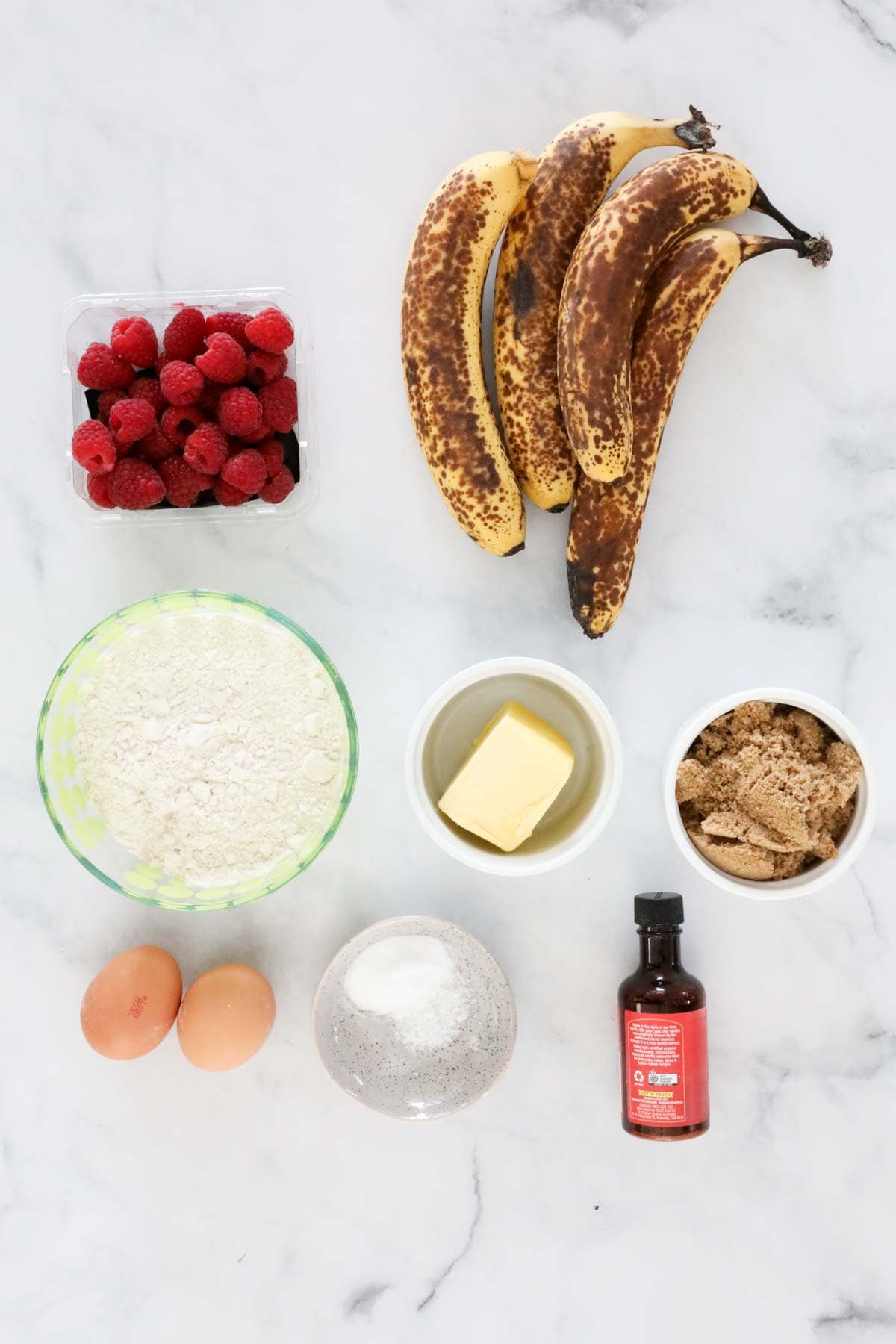 Ingredients set out on a bench for banana raspberry bread.